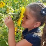 young girl smelling flower